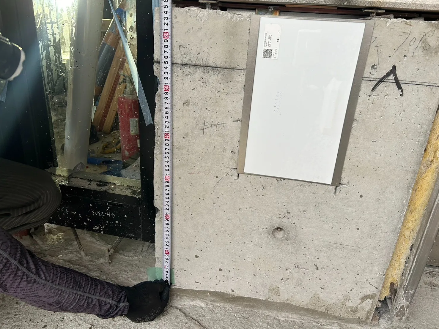 レーザーで出した基準線から高さを測定。既存下地との高低差を実測し、必要な施工厚を決定する
