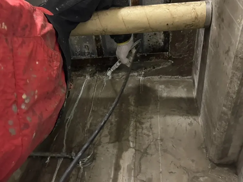 地下室のコンクリート壁で漏水箇所へ止水材を注入する施工状況